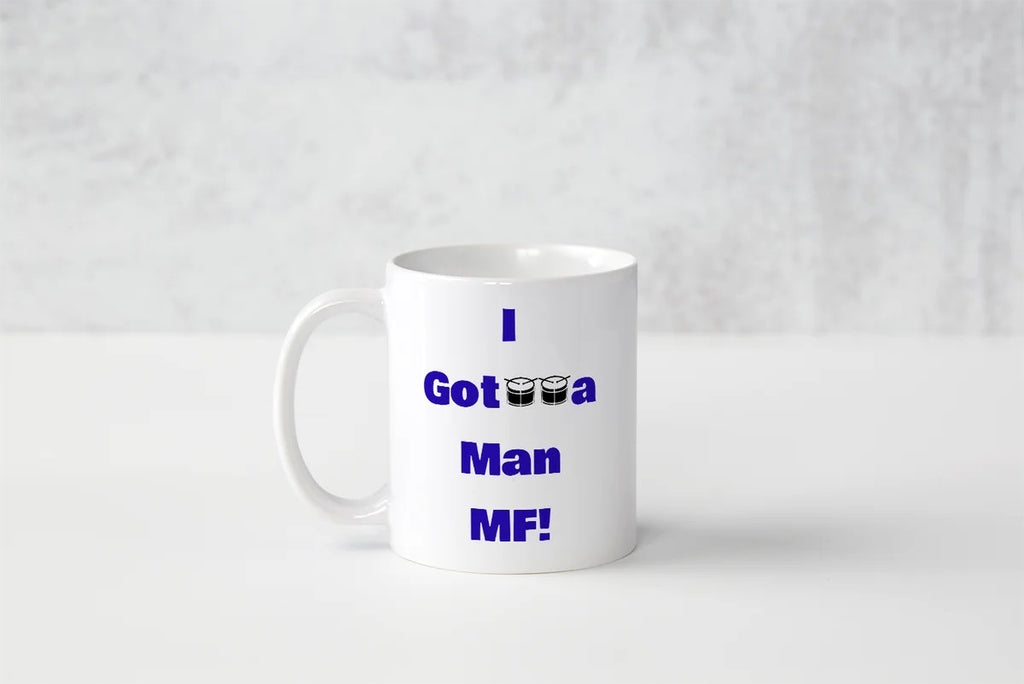 A white ceramic coffee mug with blue text reading 'I Got a Man MF!' printed on the side, set against a light gray textured background.