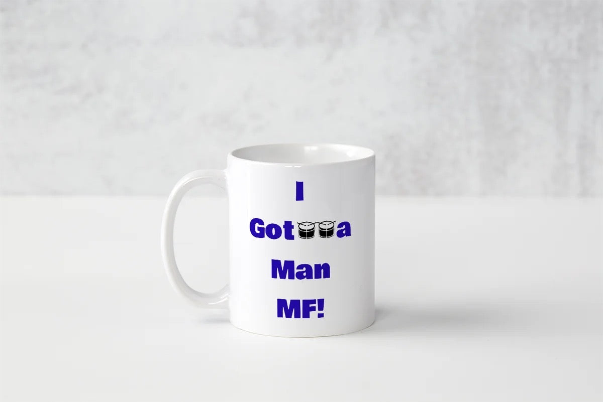 A white ceramic coffee mug with blue text reading 'I Got a Man MF!' printed on the side, set against a light gray textured background.